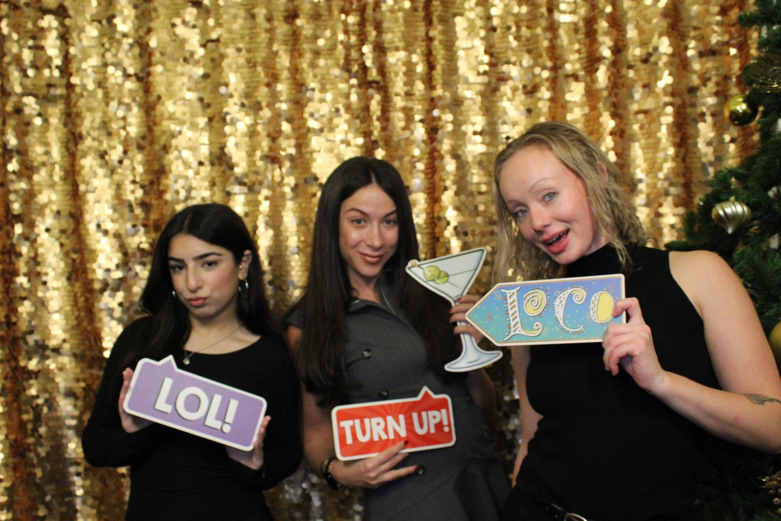 Coworkers posing at a holiday photo booth event